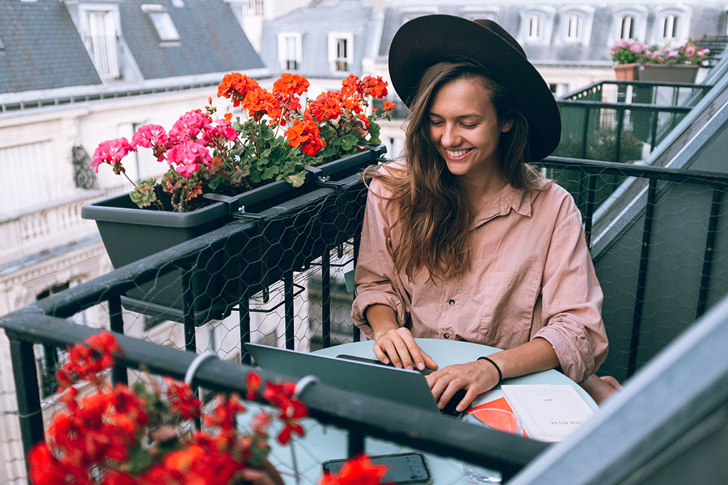 Happy woman reading fast in natural sunlight on her balcony.