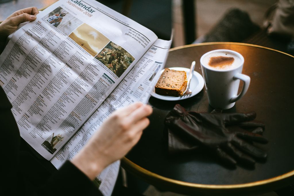 Person skimming a newspaper article as a speed reading technique.