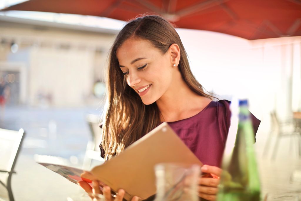 Women holding book and nodding her head back and forth as she reads to reduce eye strain and as a speed reading technique.